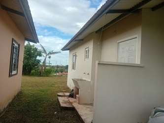 Outdoor backyard lawn space with utility features in Las Lomas David affordable rental house