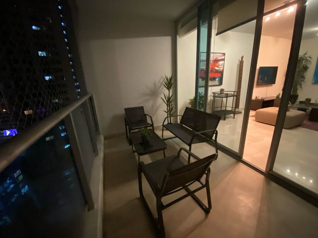Balcony with safety glass, patio seating, and Panama skyline night view