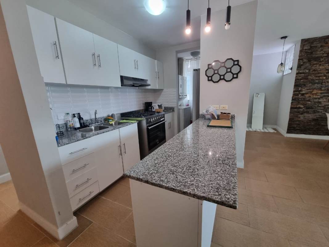 Open plan kitchen with granite counters, stove, cabinets at PH El Cangrejo Via Argentina Panama City
