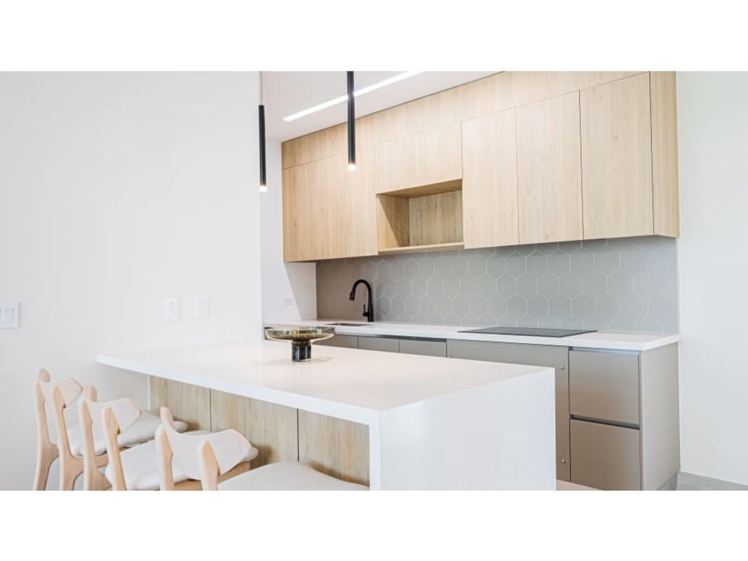 Modern bedroom with wood accent wall, large mirror, closet, city skyline view in PH Nogal Costa del Este
