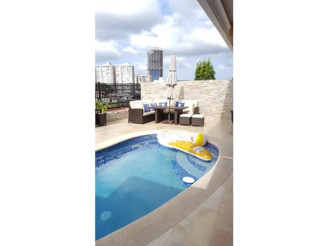 Backyard private swimming pool with natural stone waterfall and tropical landscaping in El Bosque Panama City