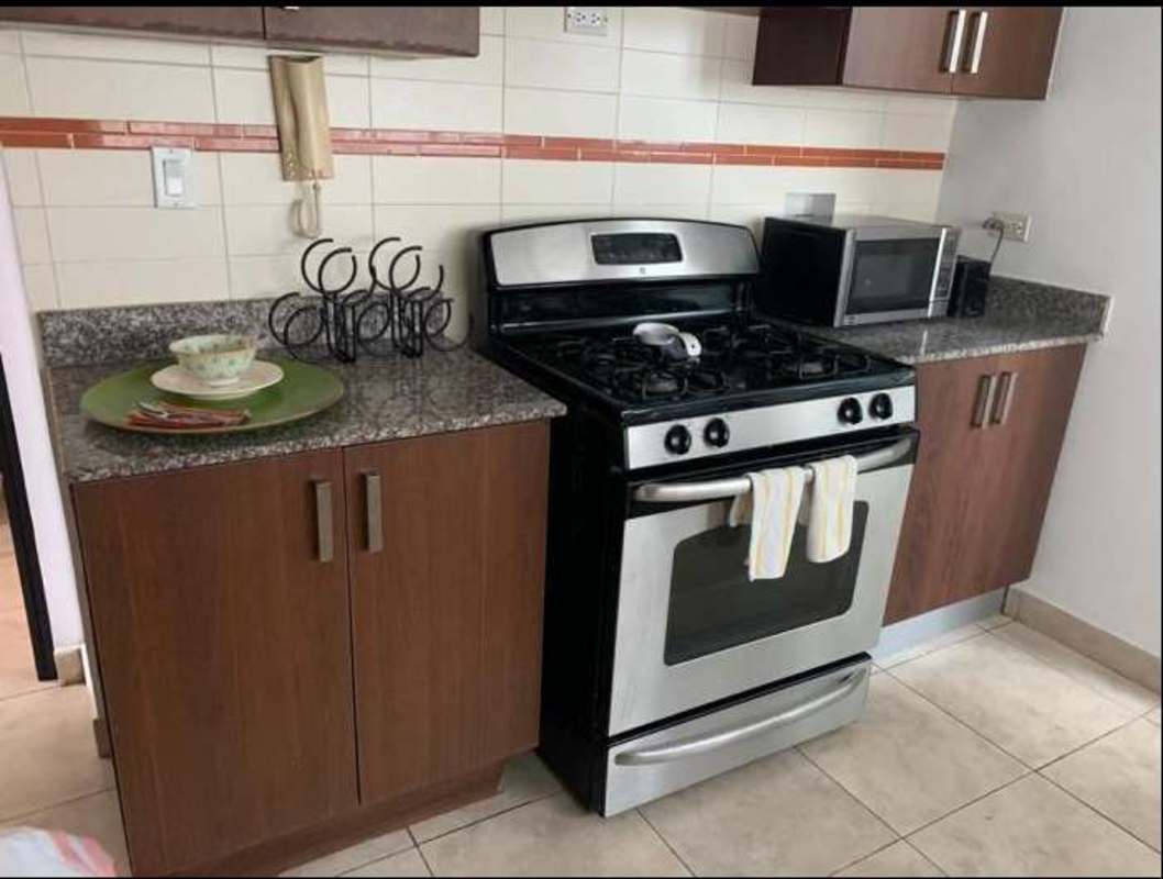 Modern bathroom with dual sinks, glass-enclosed shower and tile details PH Bella Vista Bay Panama