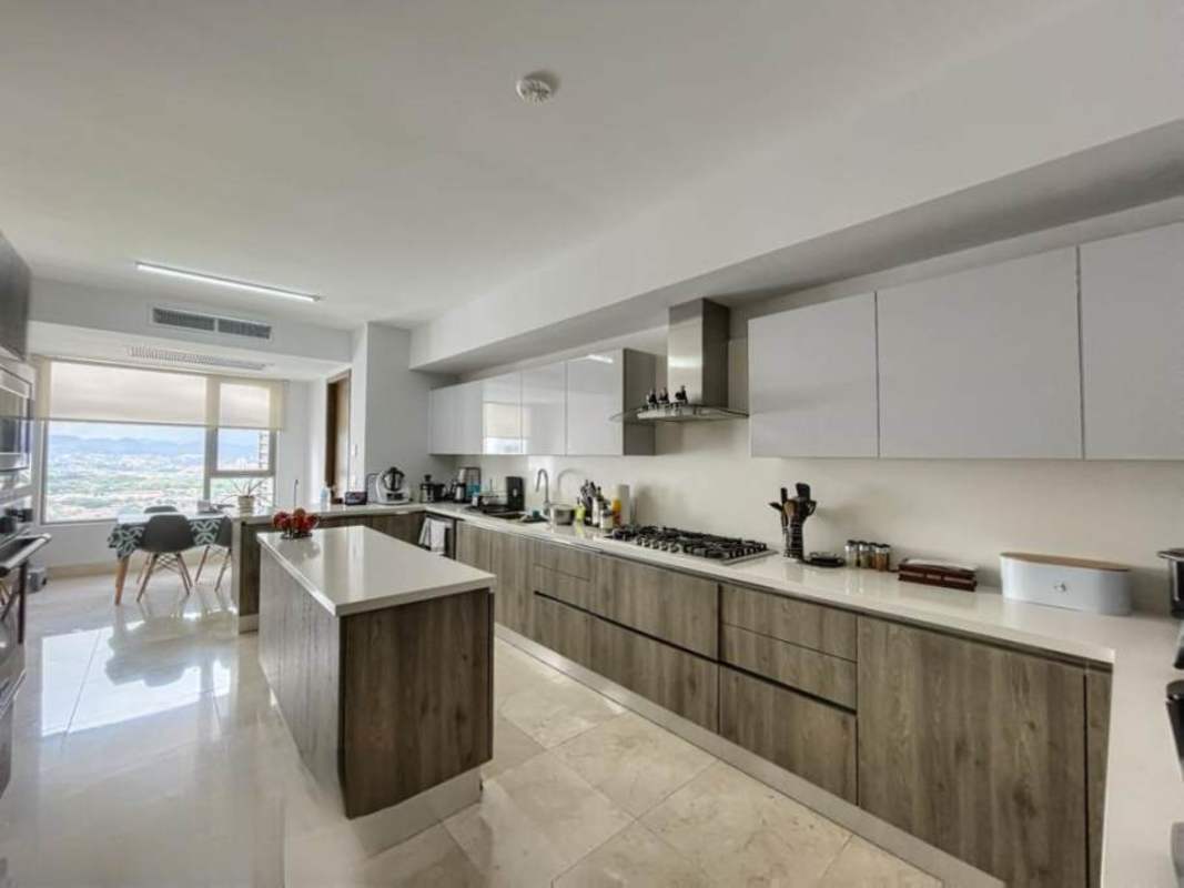 Large gourmet kitchen with modern cabinetry and big window overlooking city