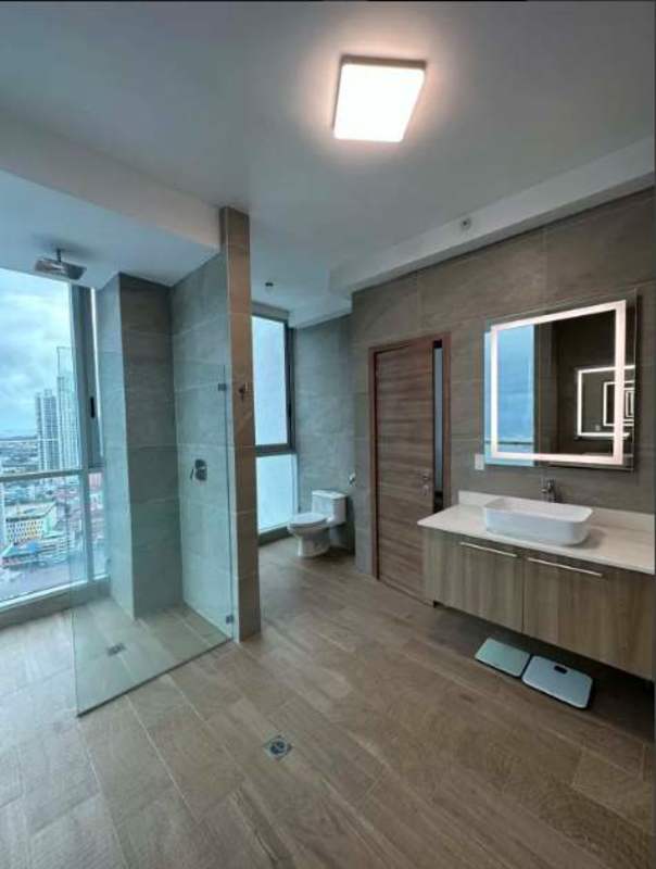Master bedroom with balcony, glass walls, and ocean view in PH BICSA penthouse Panama