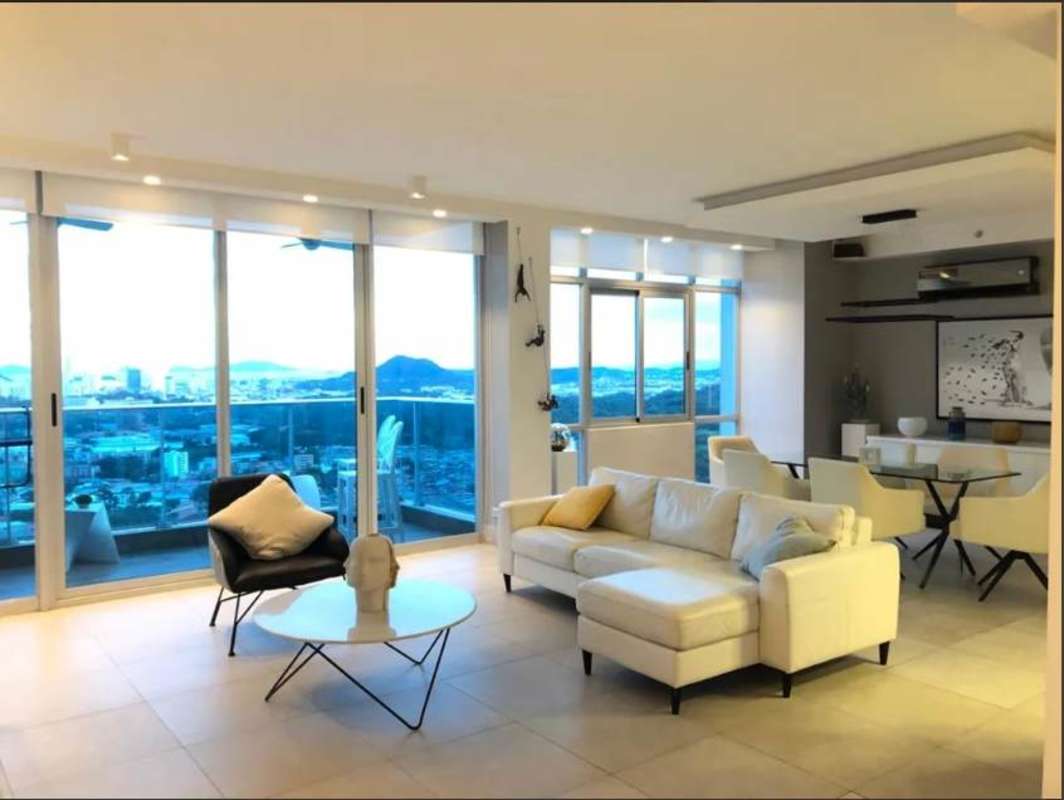 Modern living and dining room with floor-to-ceiling windows panoramic city view PH Dos Mares Betania Panama