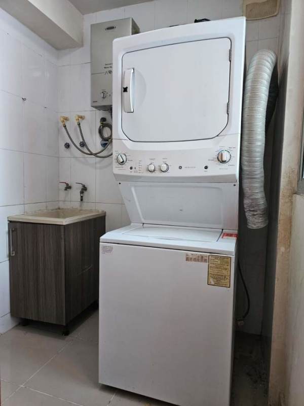 Laundry room with stacked washer dryer and utility sink PH Residencias del Sol Panama