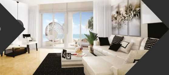 Bright living room with large glass doors opening to Pacific Ocean view terrace at Las Olas Resort Playa La Barqueta