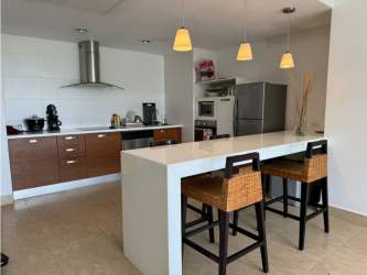 Bright contemporary kitchen with breakfast bar and appliances in Nikki Residences Playa Blanca condo for sale