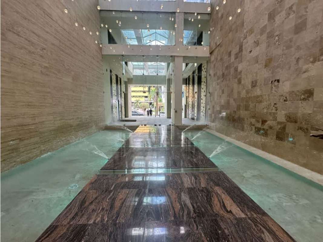 Luxury lobby with glass ceiling, marble floors and water feature in PH Lumiere Costa del Este Panama