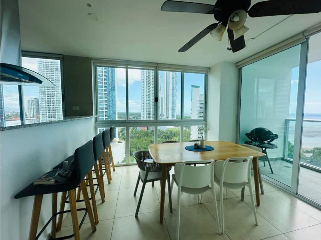 Bright dining room with sliding doors to balcony, views of ocean and skyline PH Lumiere Costa del Este Panama City