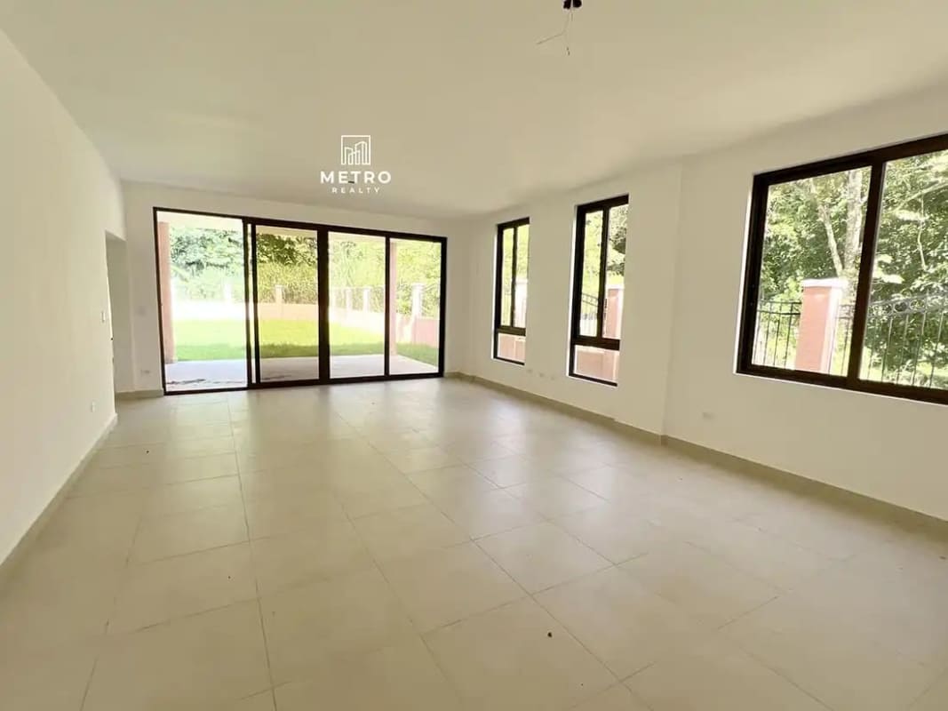 Open bright living room with multiple large windows in Clayton Forest Panama house