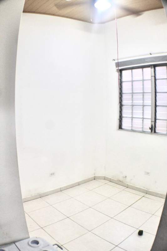 Empty room with tiled floors, barred window, ceiling fan in Llano Bonito Gardens