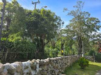 Open living area with sectional sofa and spiral staircase to mezzanine loft in rental cabin Boquete Panama