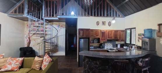 Living area with kitchen, breakfast bar and loft overhead in mountain cabin Volcancito Boquete Panama