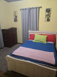 Mezzanine loft bedroom with sofa bed, triangular window in rental cabin Boquete Panama