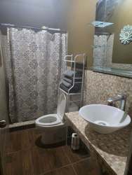 Bathroom with vessel sink, tiled counter and walk-in shower in cabin for rent Boquete Panama