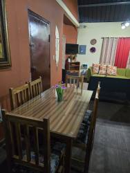 Bedroom with colorful bedspread, wooden dresser and curtains in cabin for rent Boquete Panama