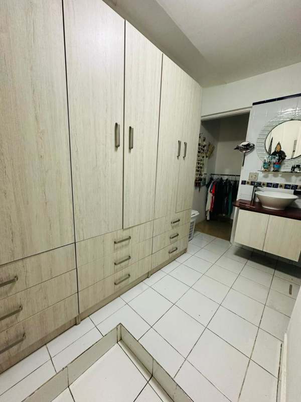 Bright enclosed porch sunroom with tiled floor and furniture in Balboa Ancón house