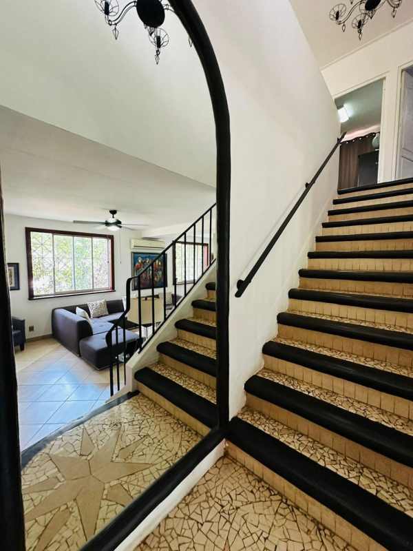 Spacious living area with decorative floors, staircase, and natural lighting in Panama home
