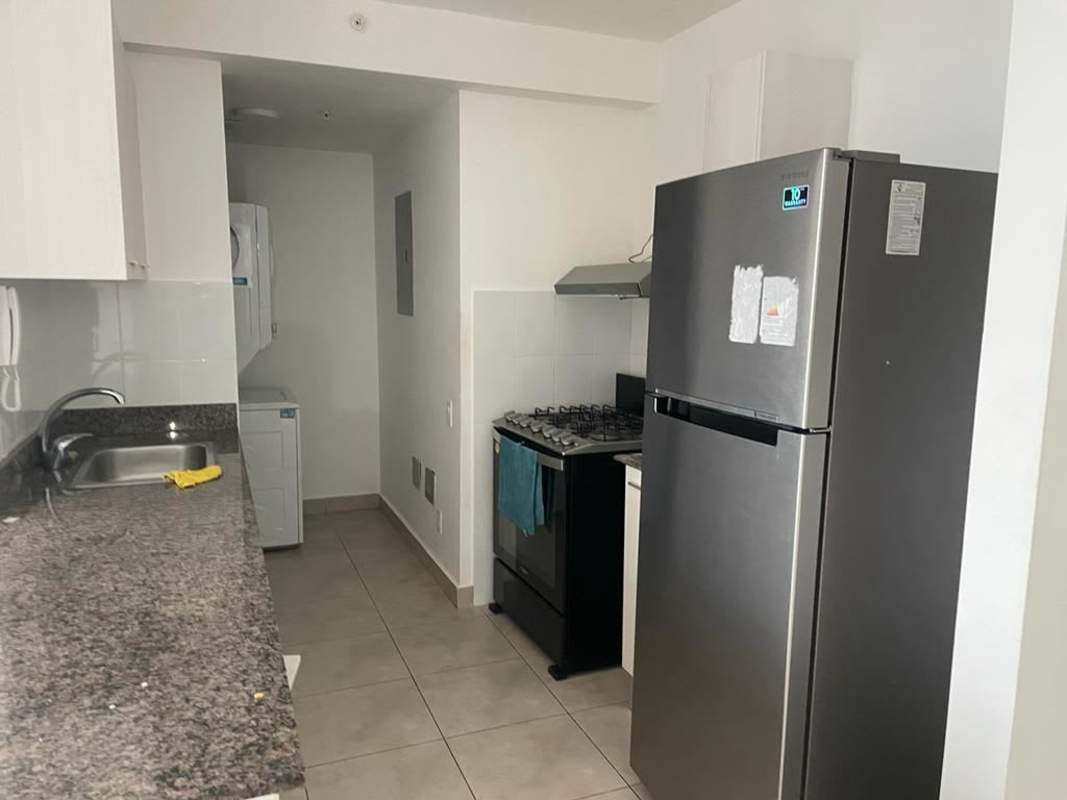 Modern kitchen with granite counters, appliances and laundry area in PH Via España Residences for rent Panama City