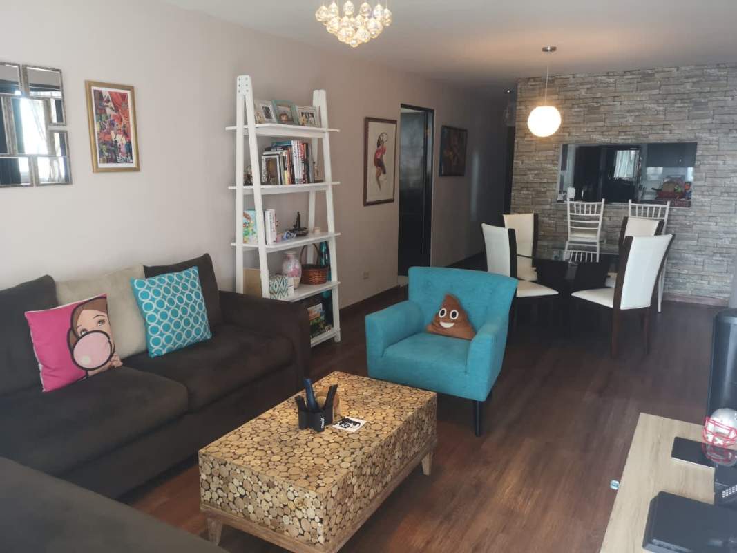 Spacious living dining area with stone wall, sectional sofa, glass dining table, floor-to-ceiling windows at PH Parque Central Panama