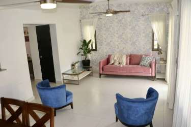 Modern open living room with light tiles, natural light, neutral decor in Panama Pacifico rental home