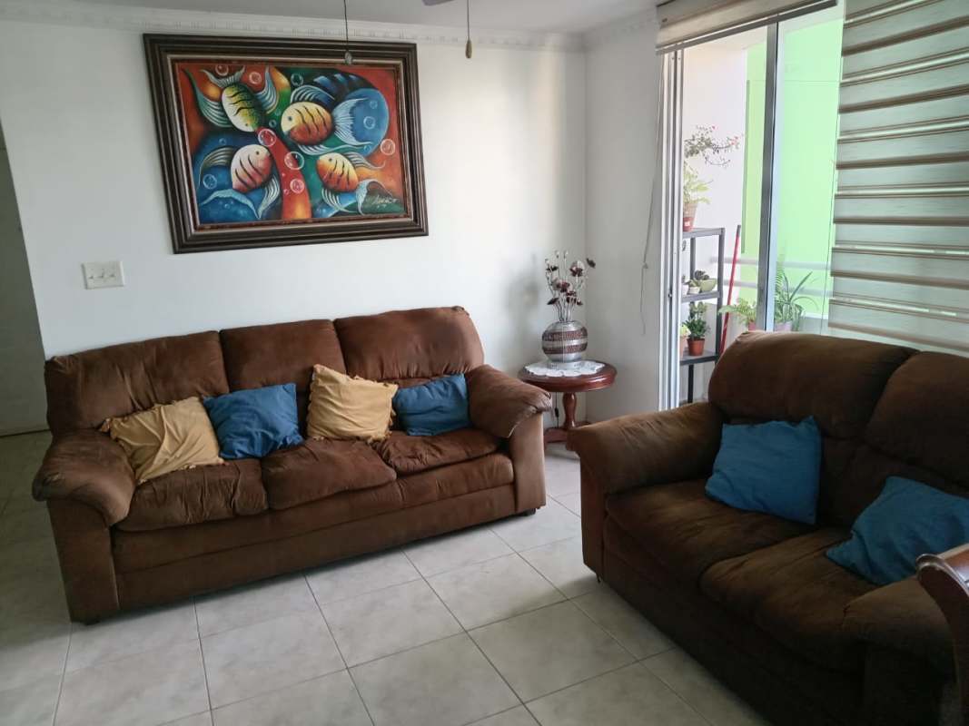 Living room with brown sofas, sliding glass door to balcony with plants in PH Riverside Condado del Rey Panama