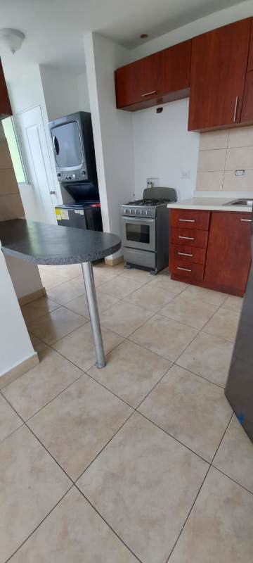 Kitchen with granite counters, tile backsplash, washer dryer setup PH Riverside Condado del Rey Panama