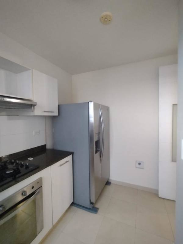 Modern kitchen with stainless steel appliances, white cabinetry and tile floor at PH Torres de Versalles Panama