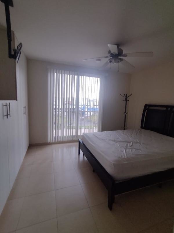 Modern bedroom with sliding glass doors, wardrobe and ceiling fan in PH Torres de Versalles Panama