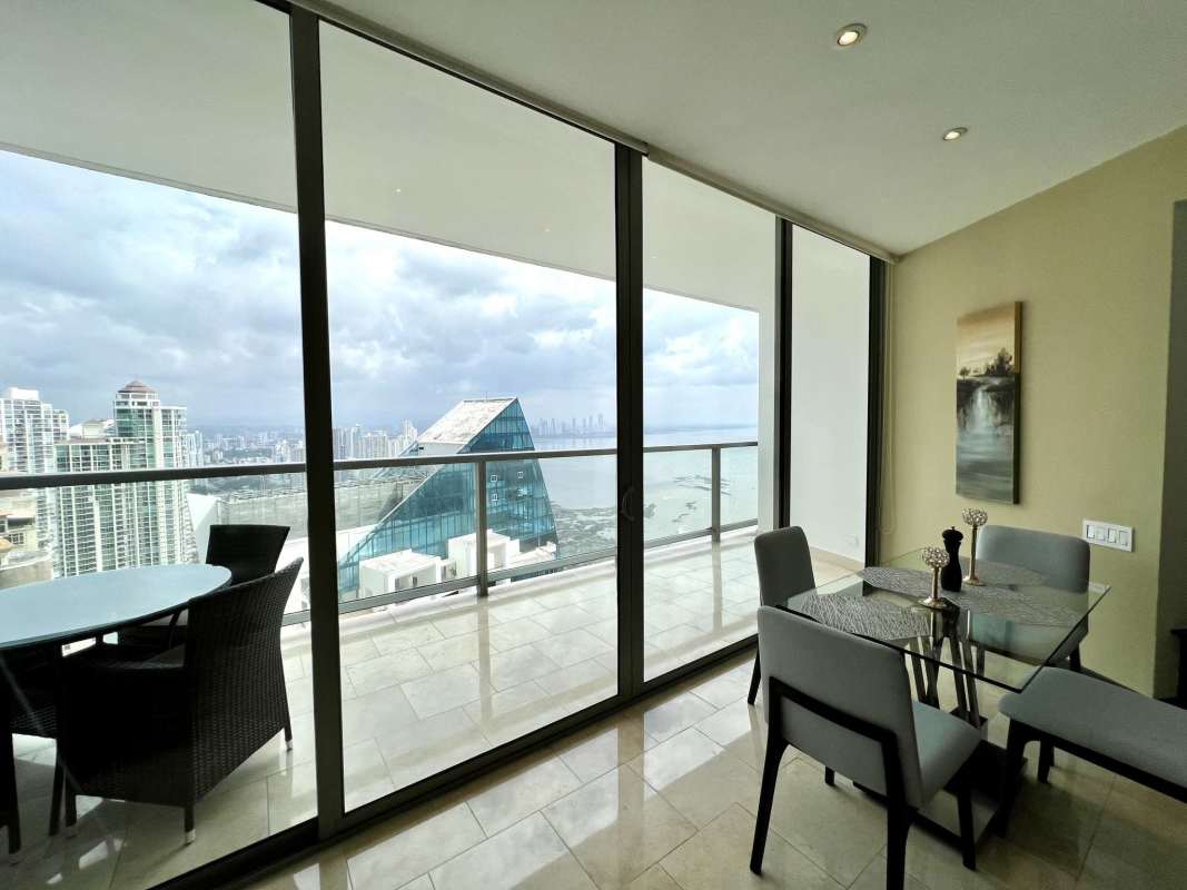 Living area with floor-to-ceiling windows overlooking ocean and skyline in JW Marriott Panama