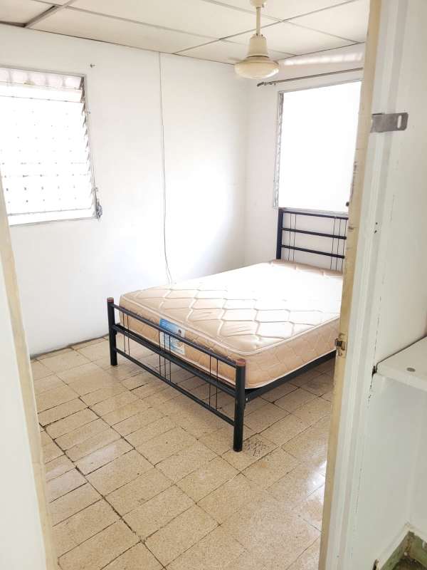 Simple bedroom with metal bed, ceiling fan, two windows Ciudad Radial Panama City