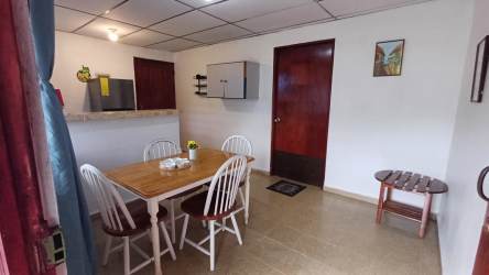 Covered patio with BBQ area, tables and chairs overlooking private pool at Malibu Beach cabins Panama