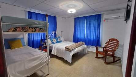 Open kitchen with microwave, gas stove, refrigerator, tile counters at Malibu Beach Gorgona cabins Panama