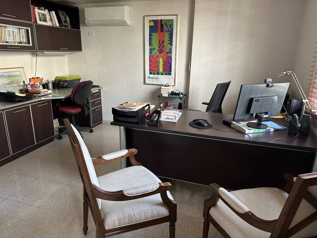 Tropical patio garden with lush plants, stone walls, outdoor seating in Villa de las Fuentes Panama