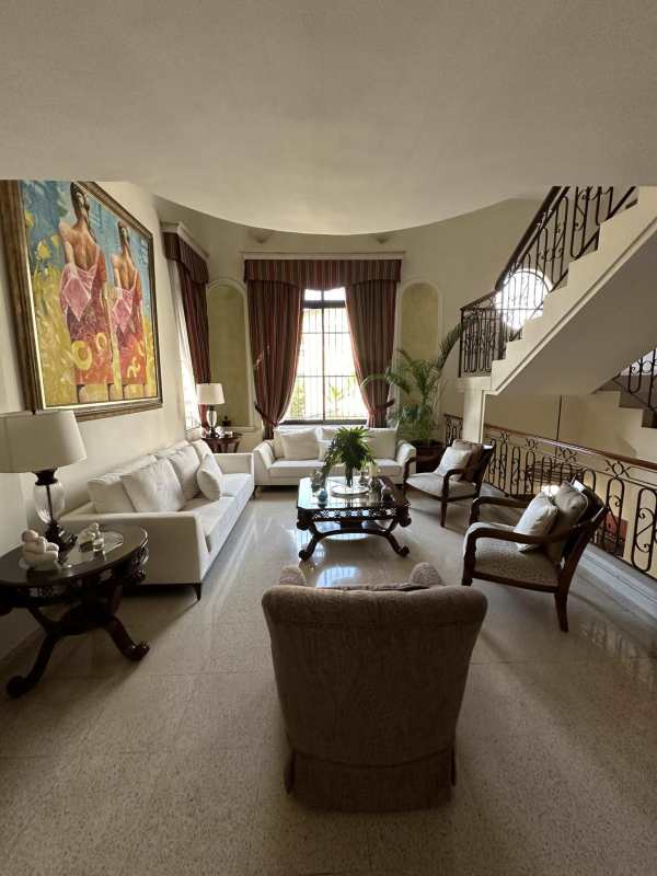 Modern kitchen with gas stove, black counters, dining nook in Villa de las Fuentes house Panama