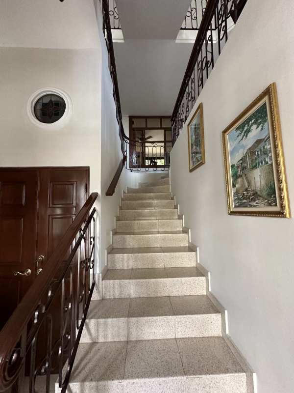 Elegant living room with large window, iron rail stair, high ceiling in Villa de las Fuentes Panama