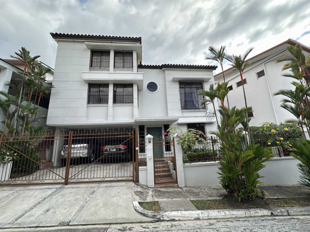 Traditional dining room with wood furniture, chandelier, bright windows in Villa de las Fuentes house