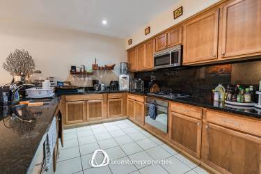 Spacious kitchen with wood cabinetry, granite countertops, stainless appliances in Buenaventura luxury condo Panama