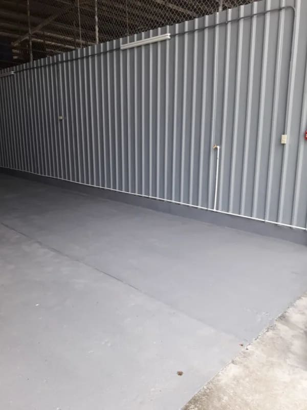 Interior open garage and warehouse space with high ceiling, metal siding and concrete floor Panama City