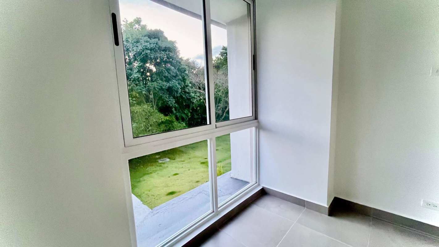 Balcony with glass railing overlooking lush garden PH Forest Gate Clayton Panama