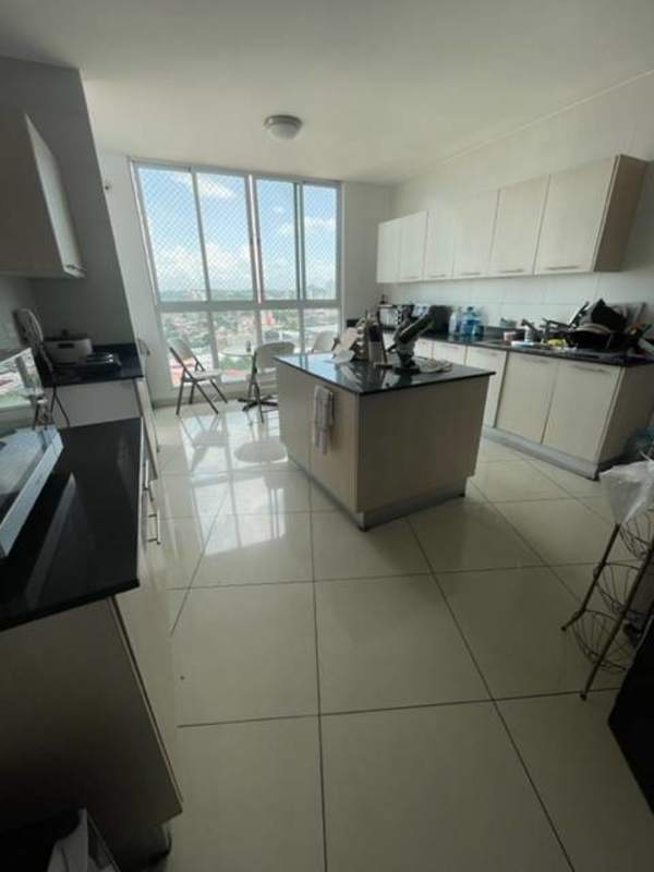 Kitchen with island countertop and windows overlooking city skyline in PH Highland View