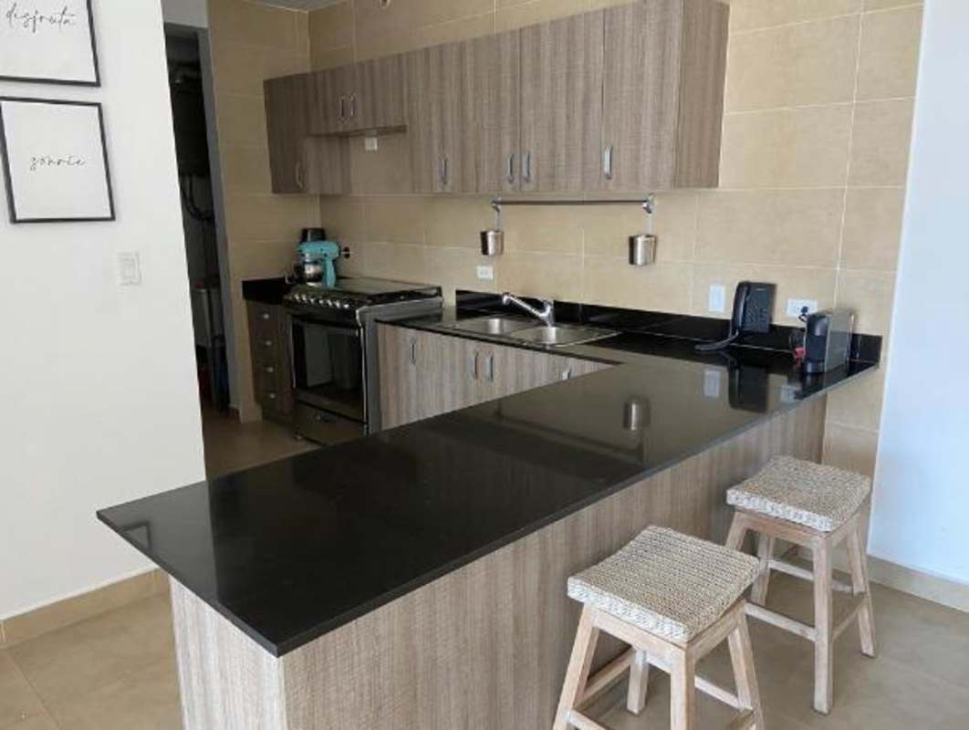Kitchen in The One Tower with granite counter, wood cabinets and seating bar Panama