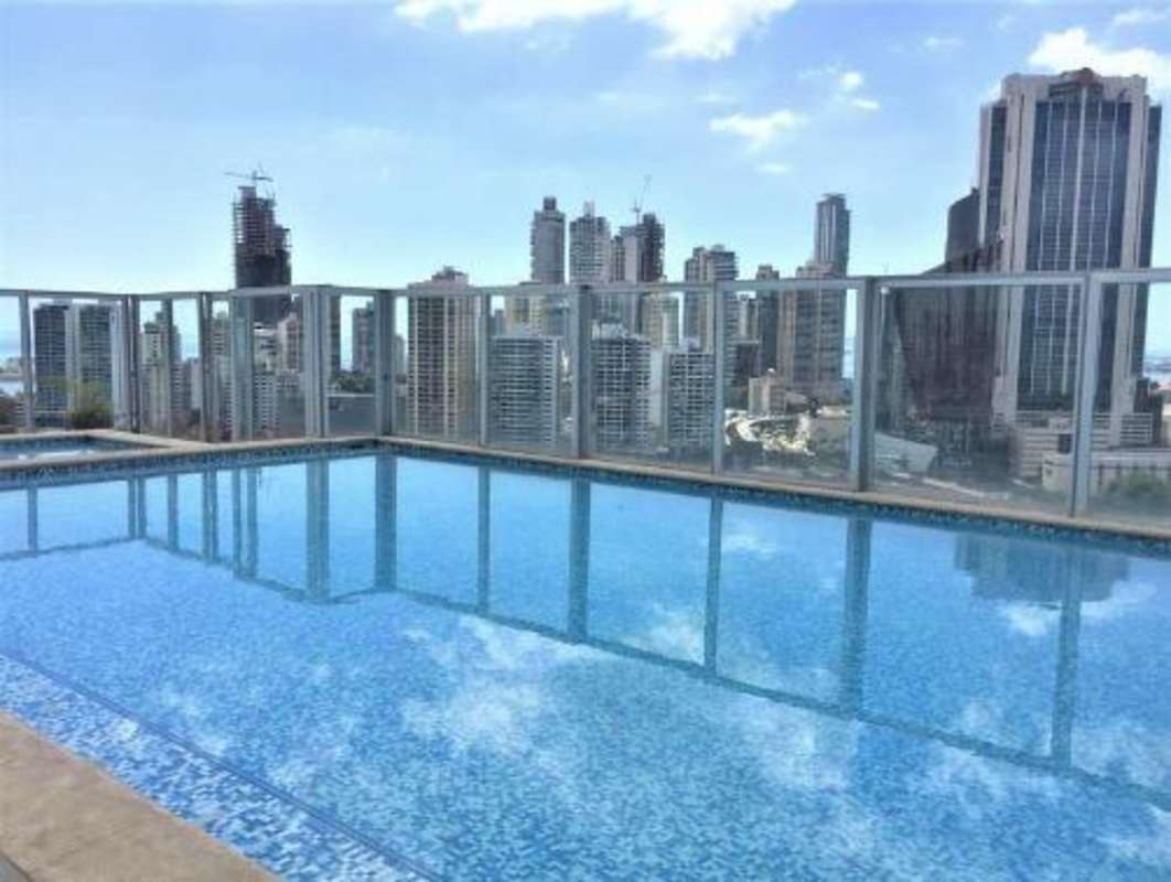 Bright living and dining area with large windows and city view in apartment at The One Tower Panama