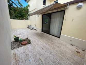 Outdoor patio area with garden beds and awning at River Valley Panama Pacifico