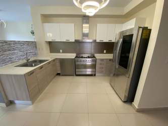 Modern kitchen with stainless appliances, double sink, tiled backsplash at River Valley Panama Pacifico