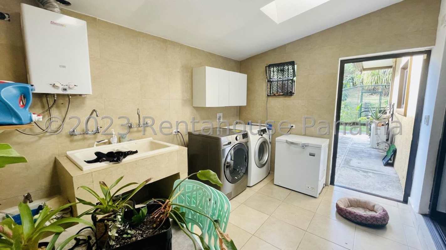 Laundry room with appliances, cabinets, freezer, skylight and garden access in Clayton house Panama City