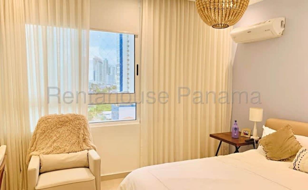 Minimalist bedroom with city view window, AC and cozy seating at Quadrat San Francisco Panama