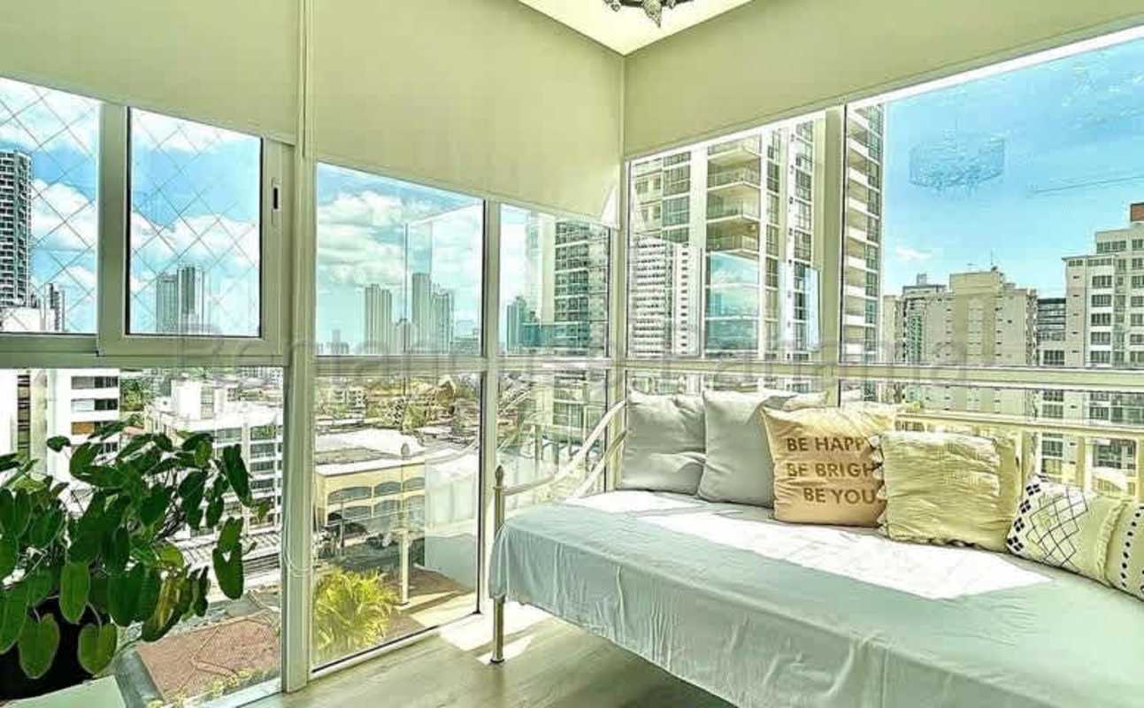 Glass enclosed balcony with panoramic city skyline view, daybed and blinds at Quadrat Panama