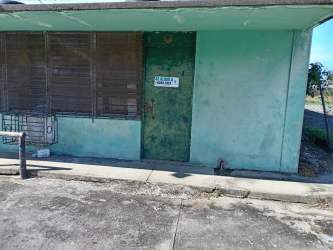Single-story warehouse with security bars, metal gate, and perimeter fence in Bugaba Panama